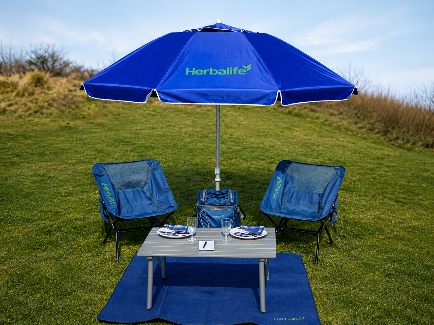Custom branded picnic backpack, outdoor table, umbrella and folding chairs developed for successive promotional merchandise programs